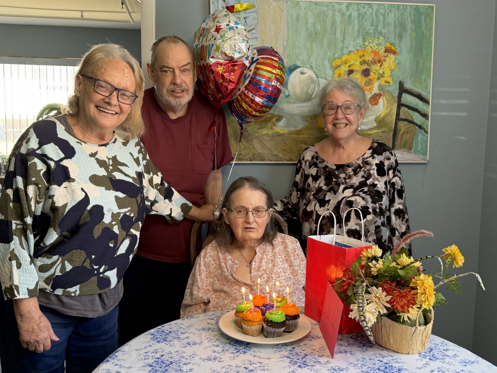 Residents and family celebrating a birthday with cupcakes