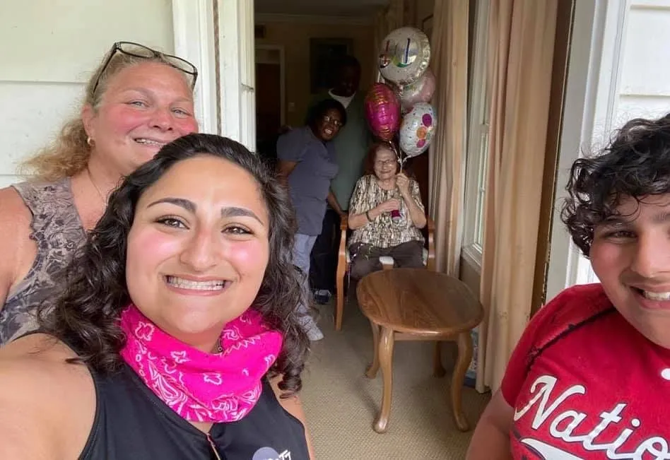 Caregivers and family with a resident on her birthday